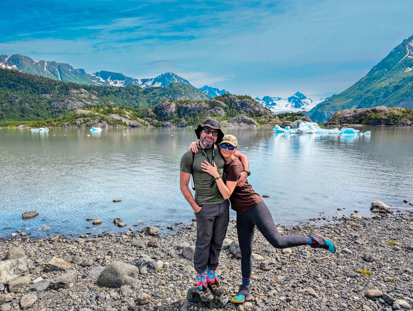 Yoni Ryabinski at an Alaska glacier lagoon with icebergs and mountains behind