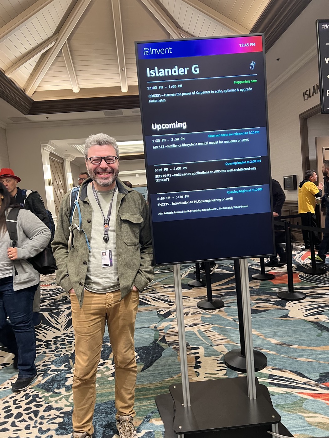 Yoni Ryabinski beside the AWS re:Invent session board for ARC312, Resilience lifecycle